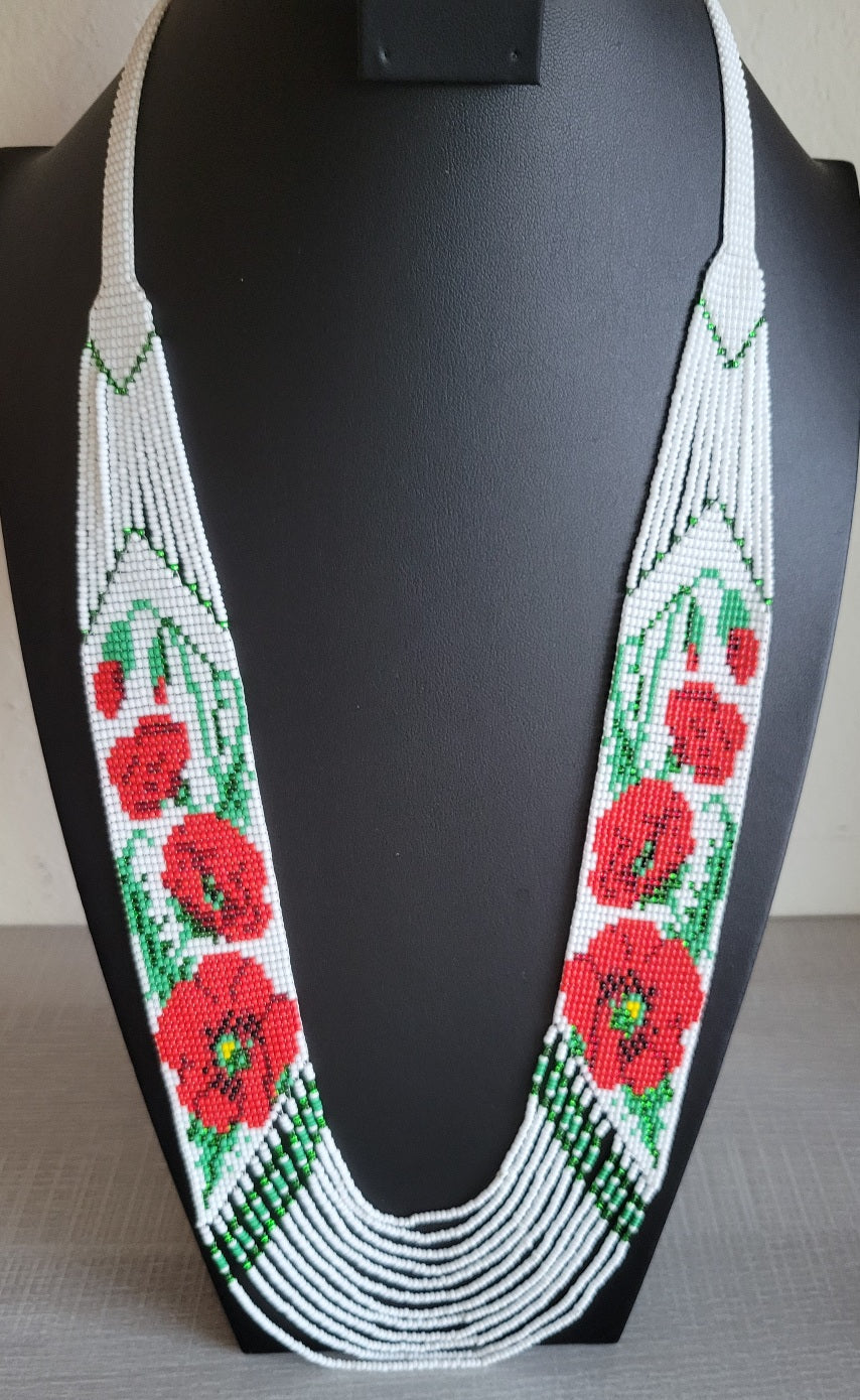 Ukrainian style beaded necklace with red poppies on white glass seed beads, shown on a black display bust