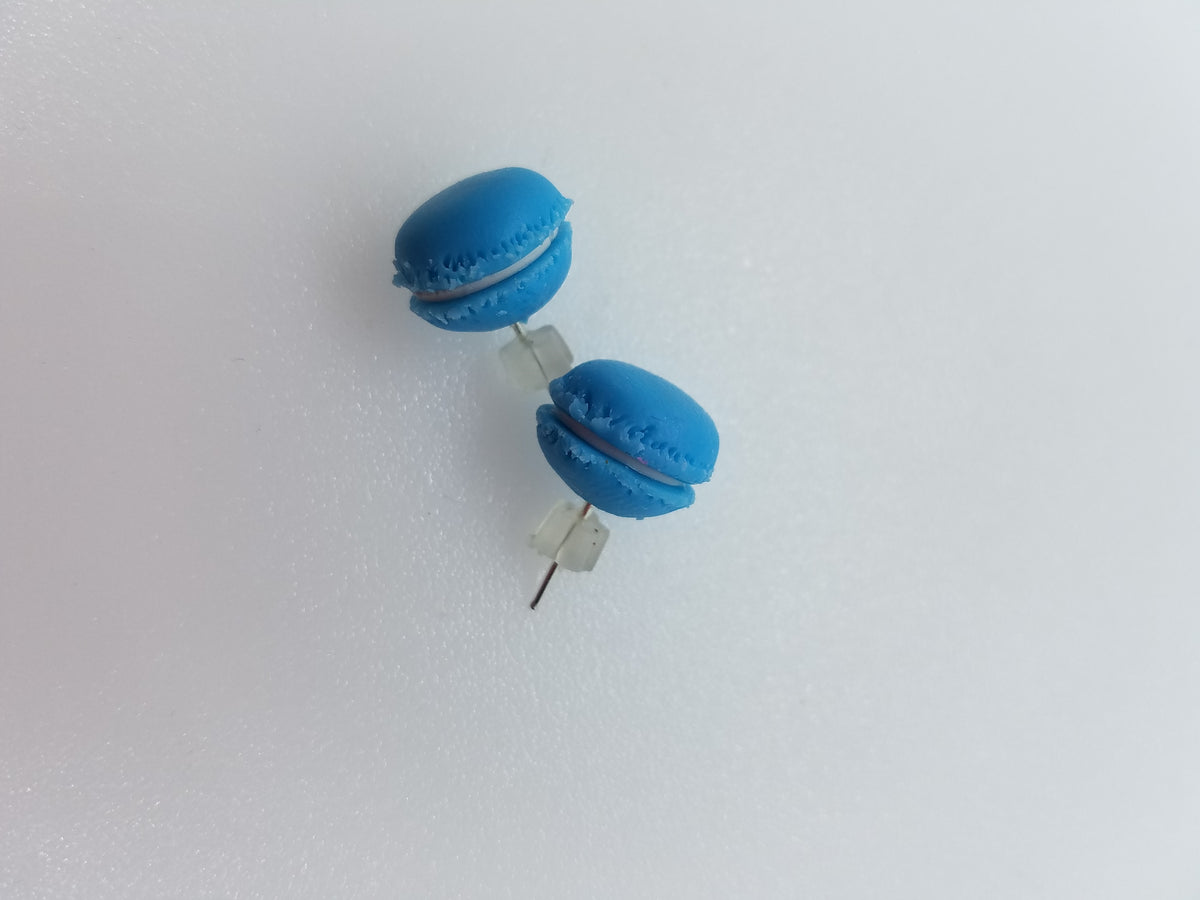 Blue macaron stud earrings handmade from polymer clay with ruffled shell detail, on a white surface