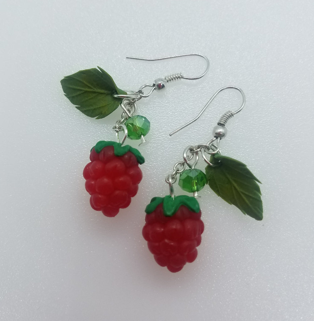Matching raspberry earrings in polymer clay with green leaves and crystals on silver hooks, companion shot