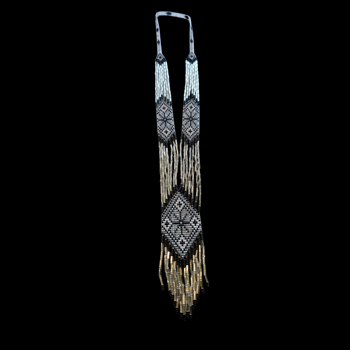 Silver, black and champagne beaded gerdan necklace glittering against a black background