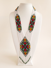 Handmade gerdan necklace of white glass seed beads with geometric folk tulip medallions in red, green and yellow