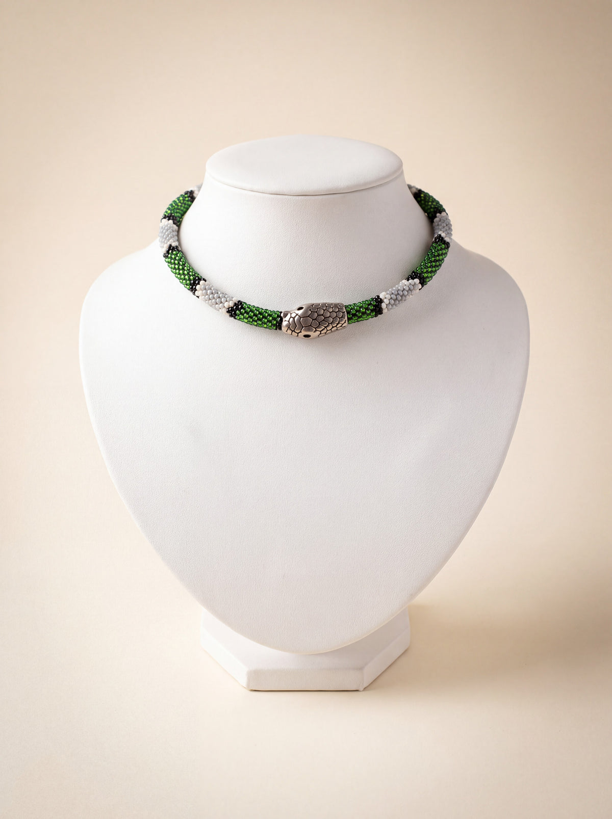 Handmade beaded snake choker with a green, white and black pattern and a silver snake head clasp