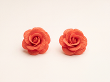 Handmade polymer clay rose flower stud earrings in coral red with delicately textured petals