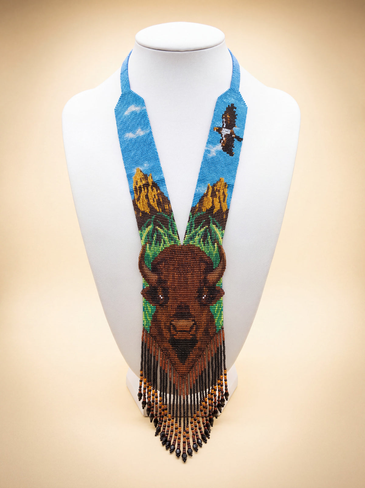 Handmade beaded gerdan necklace with a buffalo face motif, mountain sky scene with a soaring eagle in blue and brown