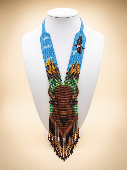Handmade beaded gerdan necklace with a buffalo face motif, mountain sky scene with a soaring eagle in blue and brown