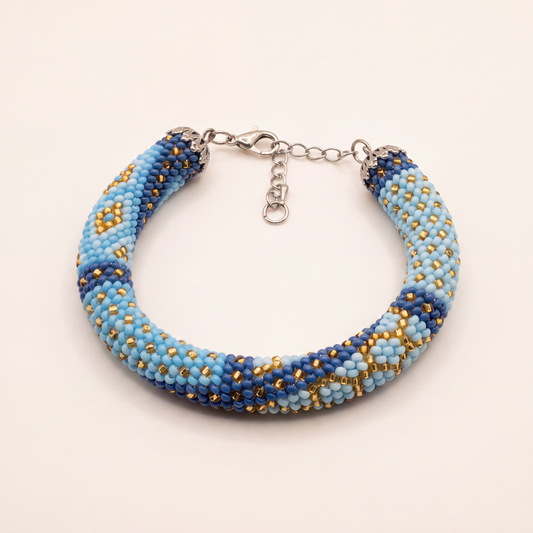 Bead crochet rope bracelet in sky blue, navy and gold diamond pattern with adjustable silver clasp