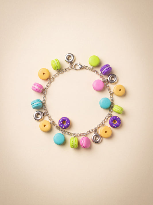 Handmade polymer clay charm bracelet with colorful donut and macaron charms on a silver chain.
