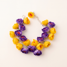 Handmade polymer clay bracelet with purple and yellow crocus flower charms on a silver chain