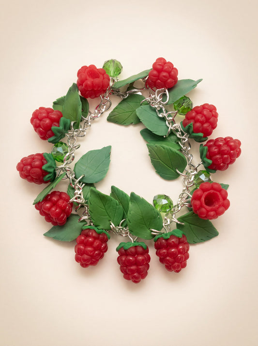 Handmade polymer clay raspberry charm bracelet with red berries and green leaves on a silver chain