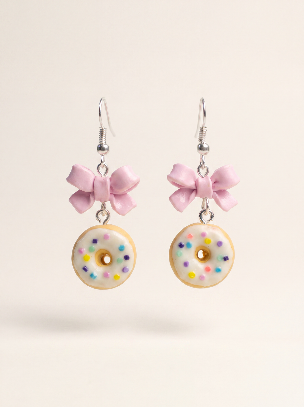 Donut earrings handmade from polymer clay, white glazed donuts with sprinkles and pink bows