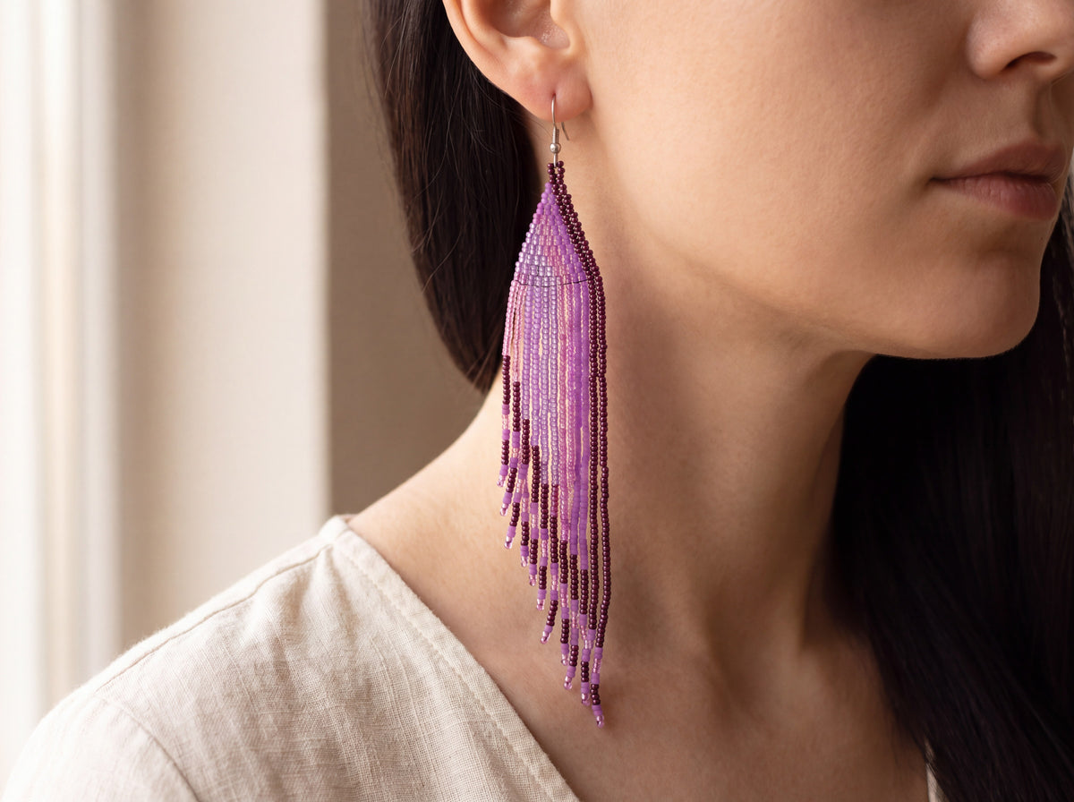 Extra long purple beaded fringe earring worn on the ear, cascading almost to the shoulder