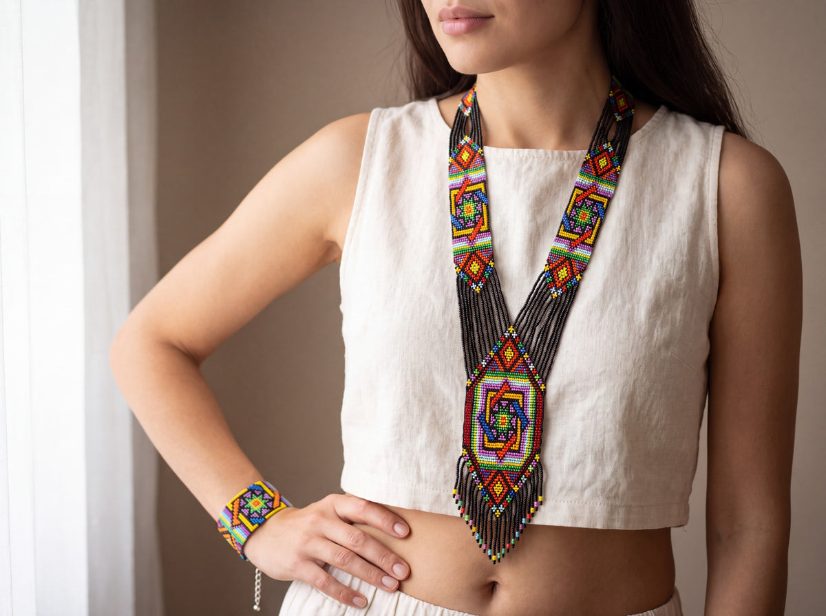 Model wearing a handmade multicolor beaded mandala gerdan necklace with black fringe and matching loom-woven bracelet on the wrist.