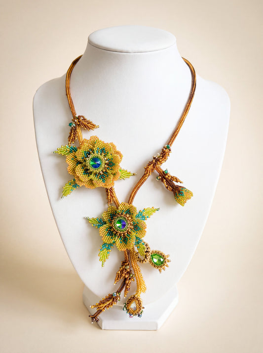 Handmade beaded "Lorien" necklace with layered gold and green flowers, crystal centers, nature motif