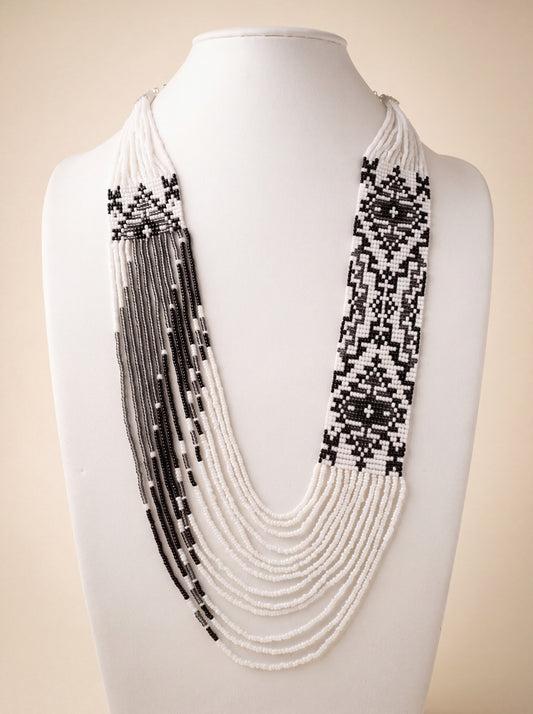 Handmade beaded "Asymmetry" necklace with black and white geometric panels and cascading fringe strands