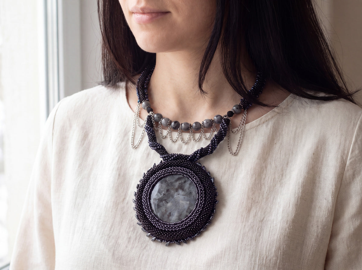 Black Moon beaded necklace worn, larvikite medallion resting on the chest