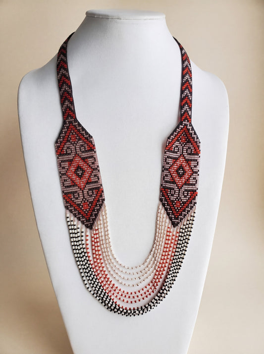 Handmade beaded necklace "Solomiya" with loomed red, black and cream diamond pattern and fringe strands.