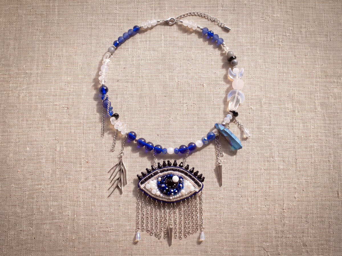 Evil eye necklace laid flat from above showing the full bead strand, chains and charms