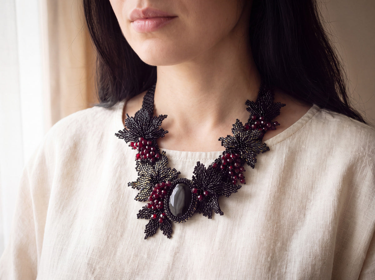 Black stone berries collar worn, resting on the collarbones