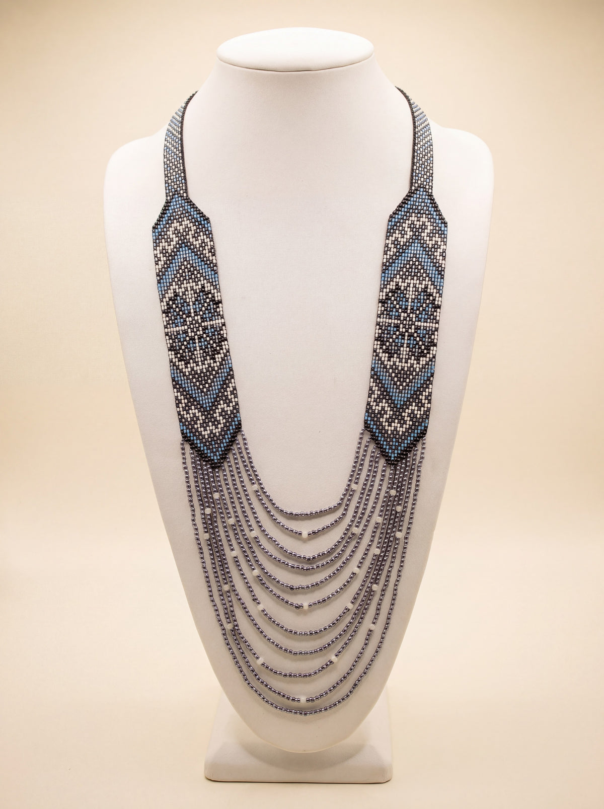 Handmade beaded necklace "Oresta" with loomed black, white and dusty blue diamond pattern and silver-tone fringe.
