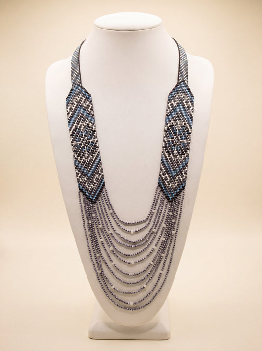 Handmade beaded necklace "Oresta" with loomed black, white and dusty blue diamond pattern and silver-tone fringe.