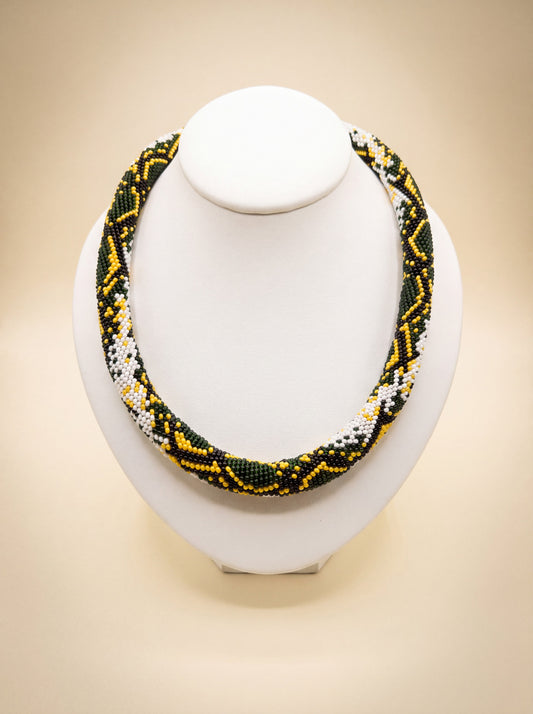 Handmade bead-crochet rope necklace with a green, yellow and white snake-scale pattern.