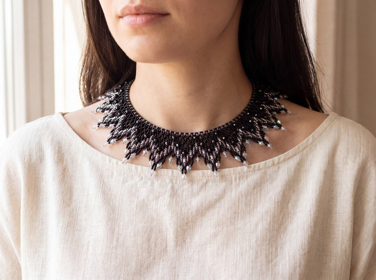 Grey and silver beaded sunburst collar worn at the neckline