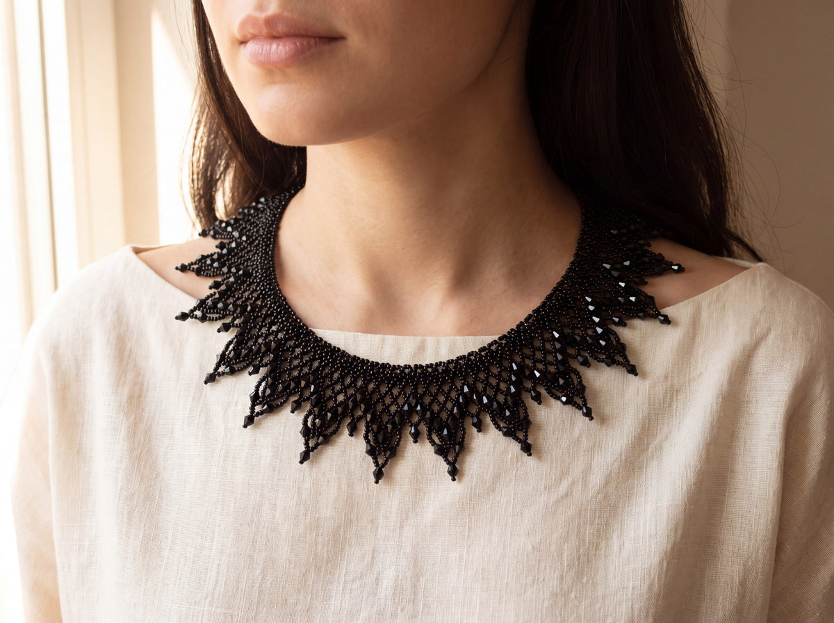 All-black beaded sunburst collar worn at the neckline