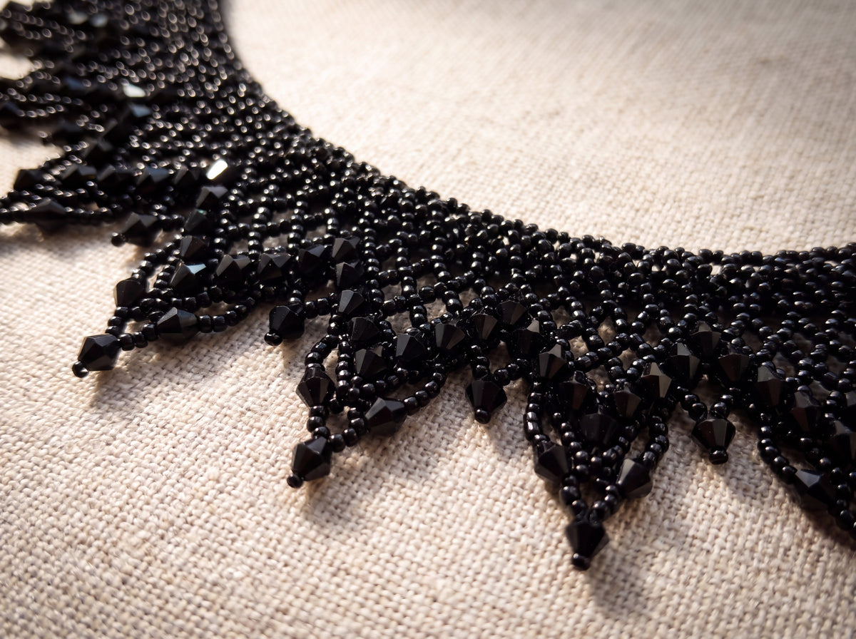 Macro detail of black beaded rays tipped with black faceted crystals
