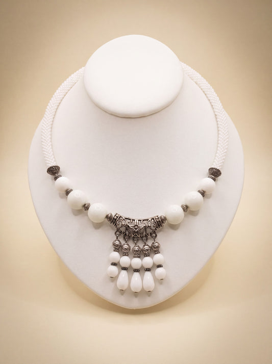 Handmade beaded rope necklace "White Queen" with white beads and an ornate silver-tone filigree pendant with dangles.