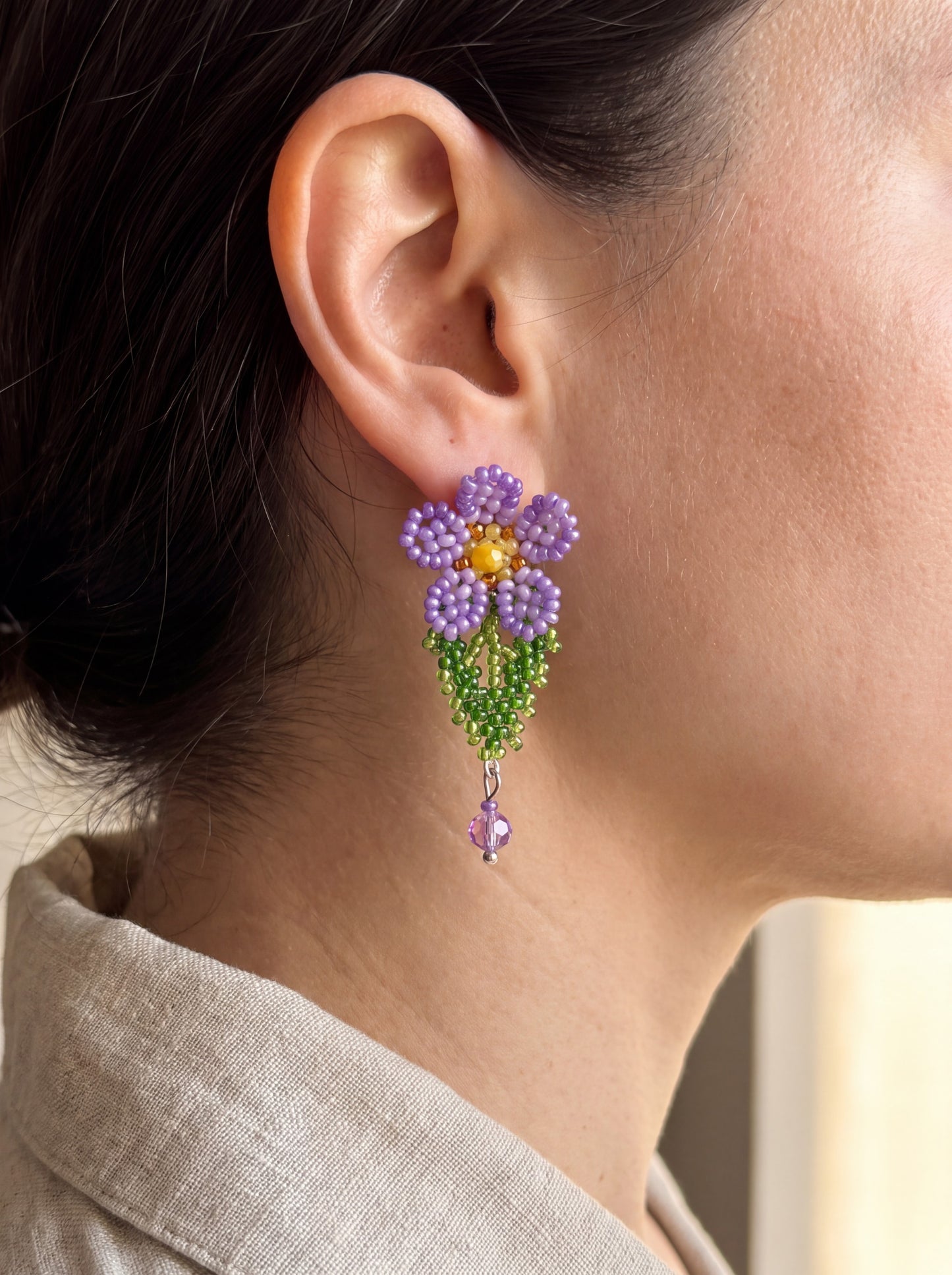Beaded violet drop earring from the "Violets" set worn on the ear, showing true size