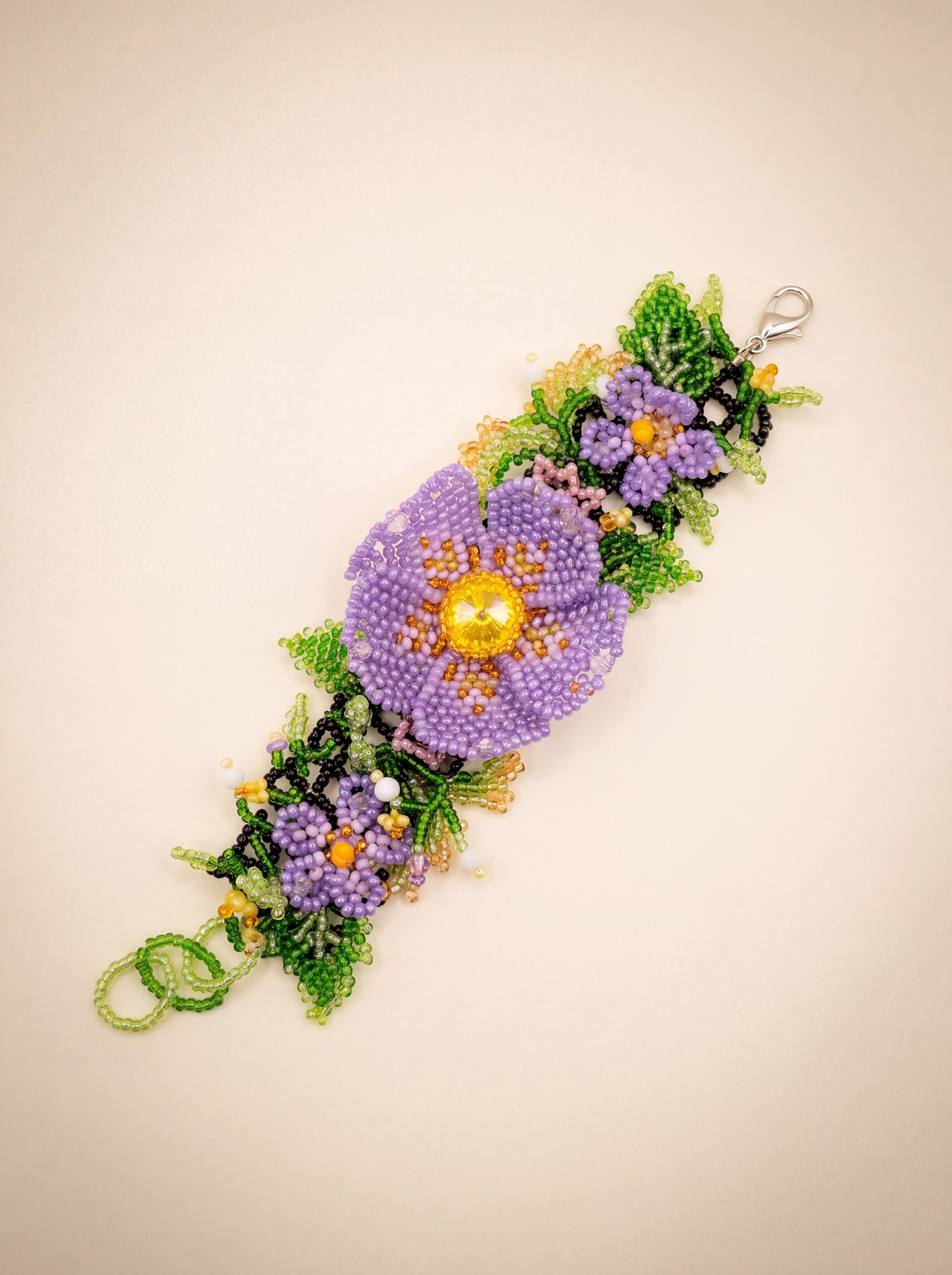 "Violets" beaded bracelet laid out full length showing the beaded loop and silver lobster clasp