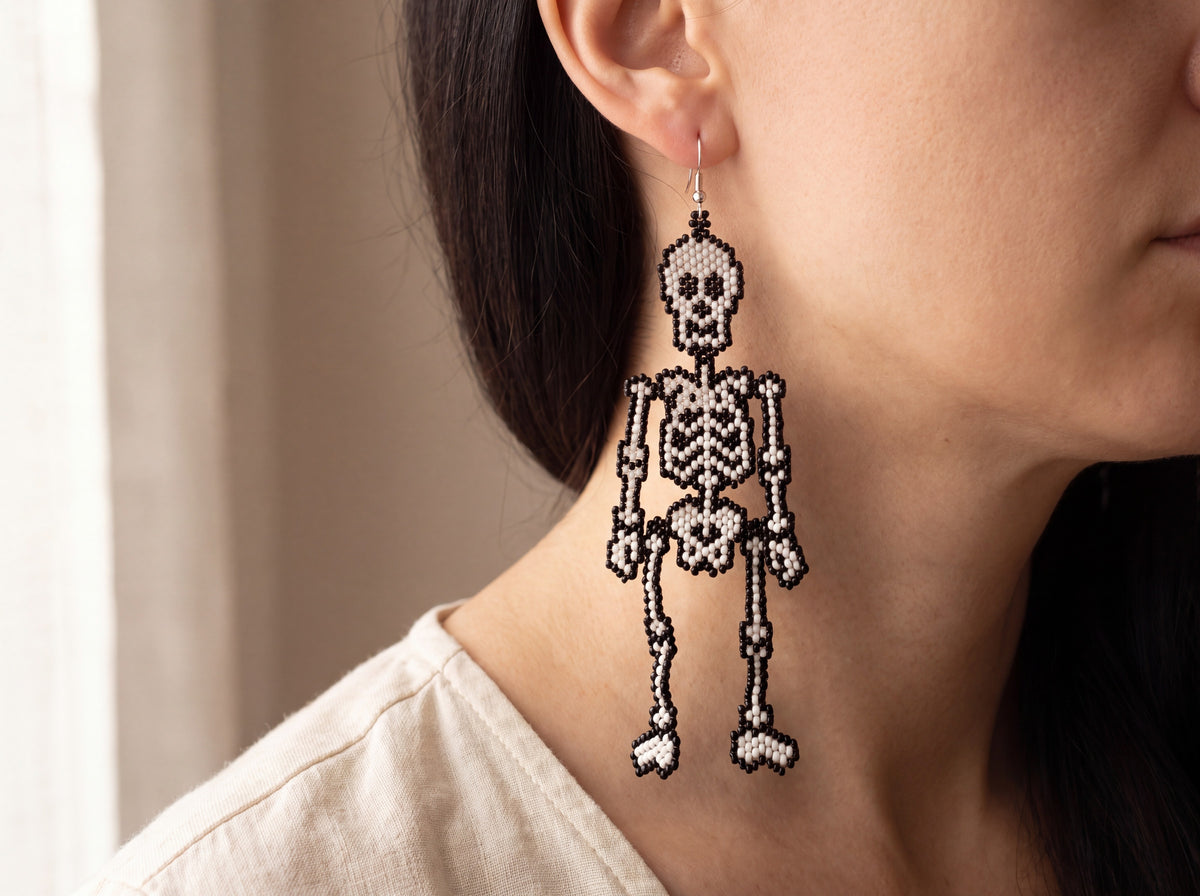 Beaded skeleton earring worn on the ear, showing full length against the jaw and neck