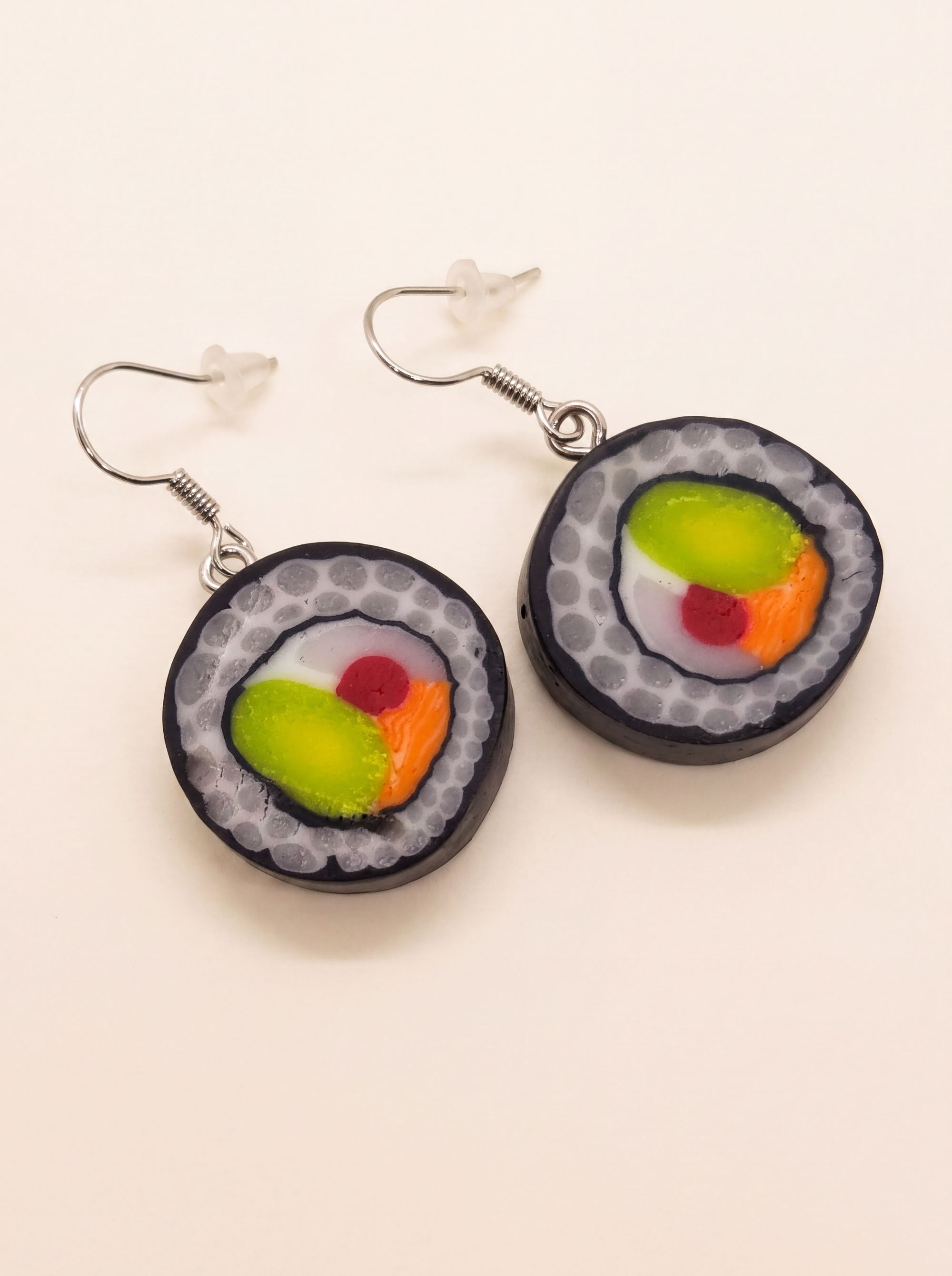 Sushi roll earrings handmade from polymer clay with salmon, avocado and rice detail on silver hooks