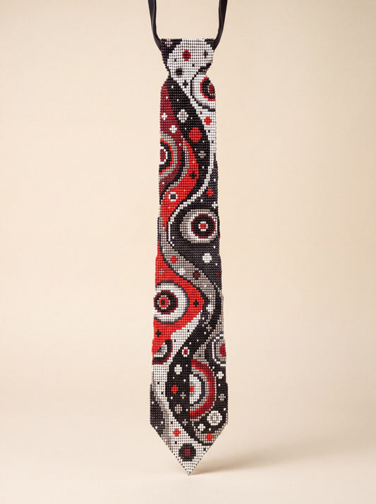 Handmade beaded necktie with a swirling red, black, white and gray abstract space-inspired pattern.