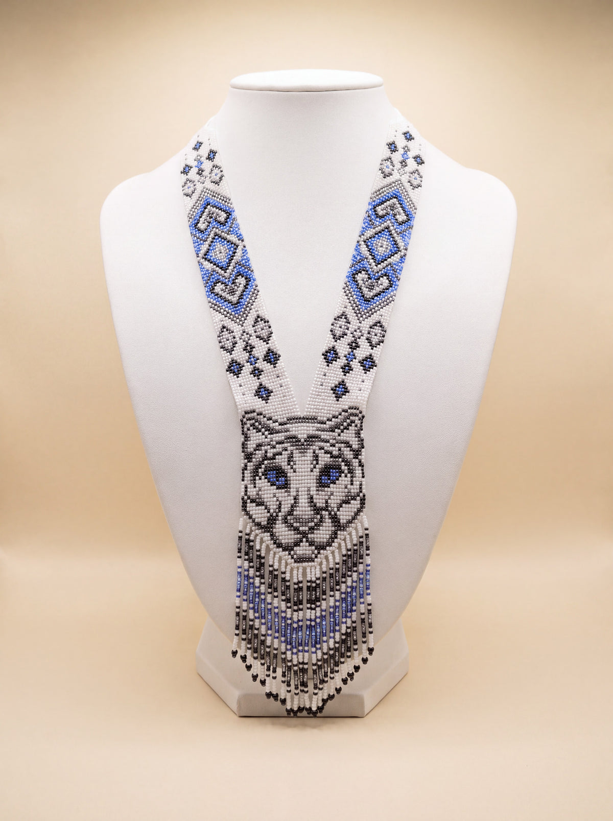 Handmade beaded gerdan necklace with a tiger face motif in white, blue, gray and black glass seed beads, fringe trim.
