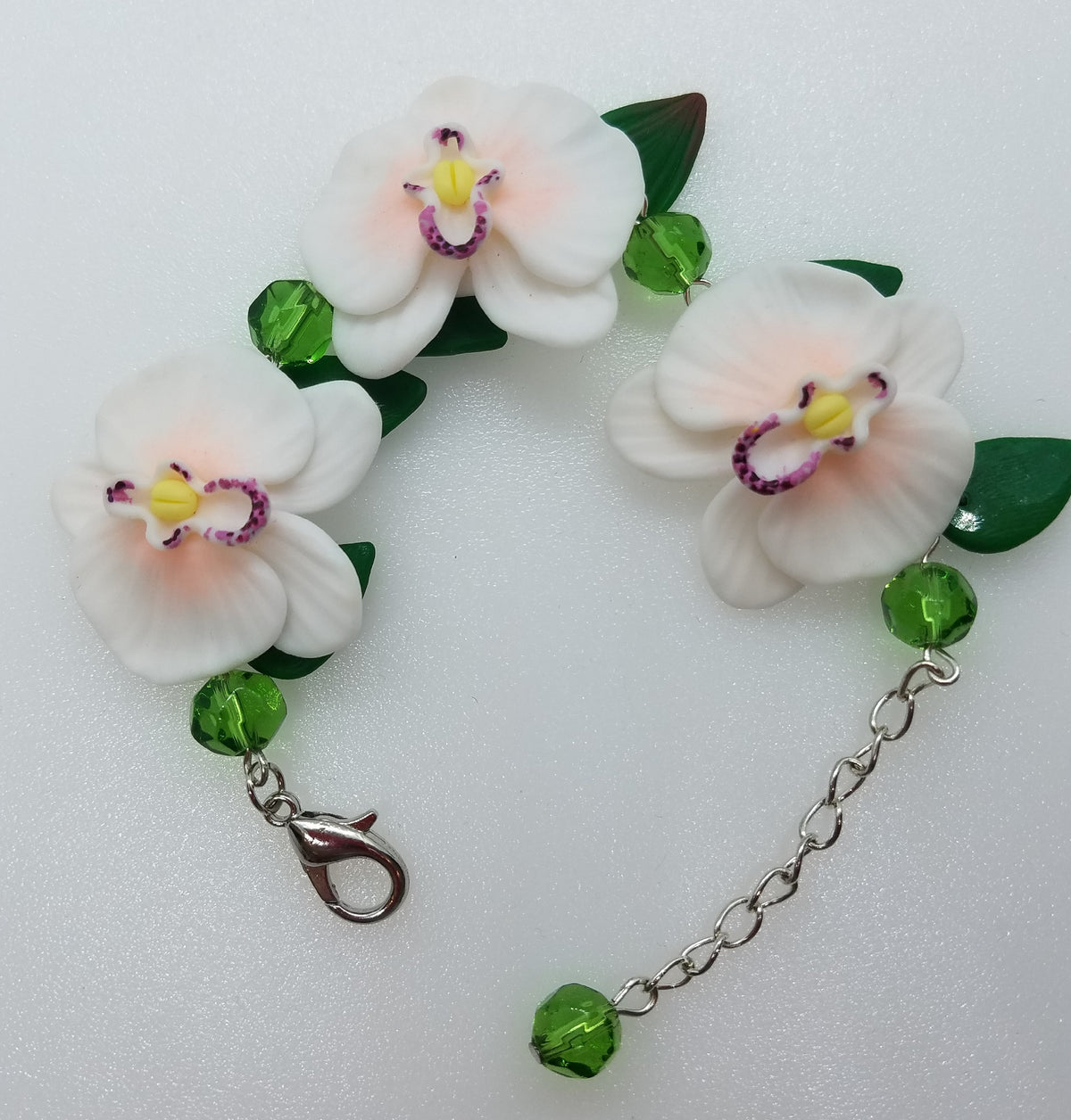 Handmade polymer clay bracelet with white orchid flowers, green leaves and glass beads on silver chain