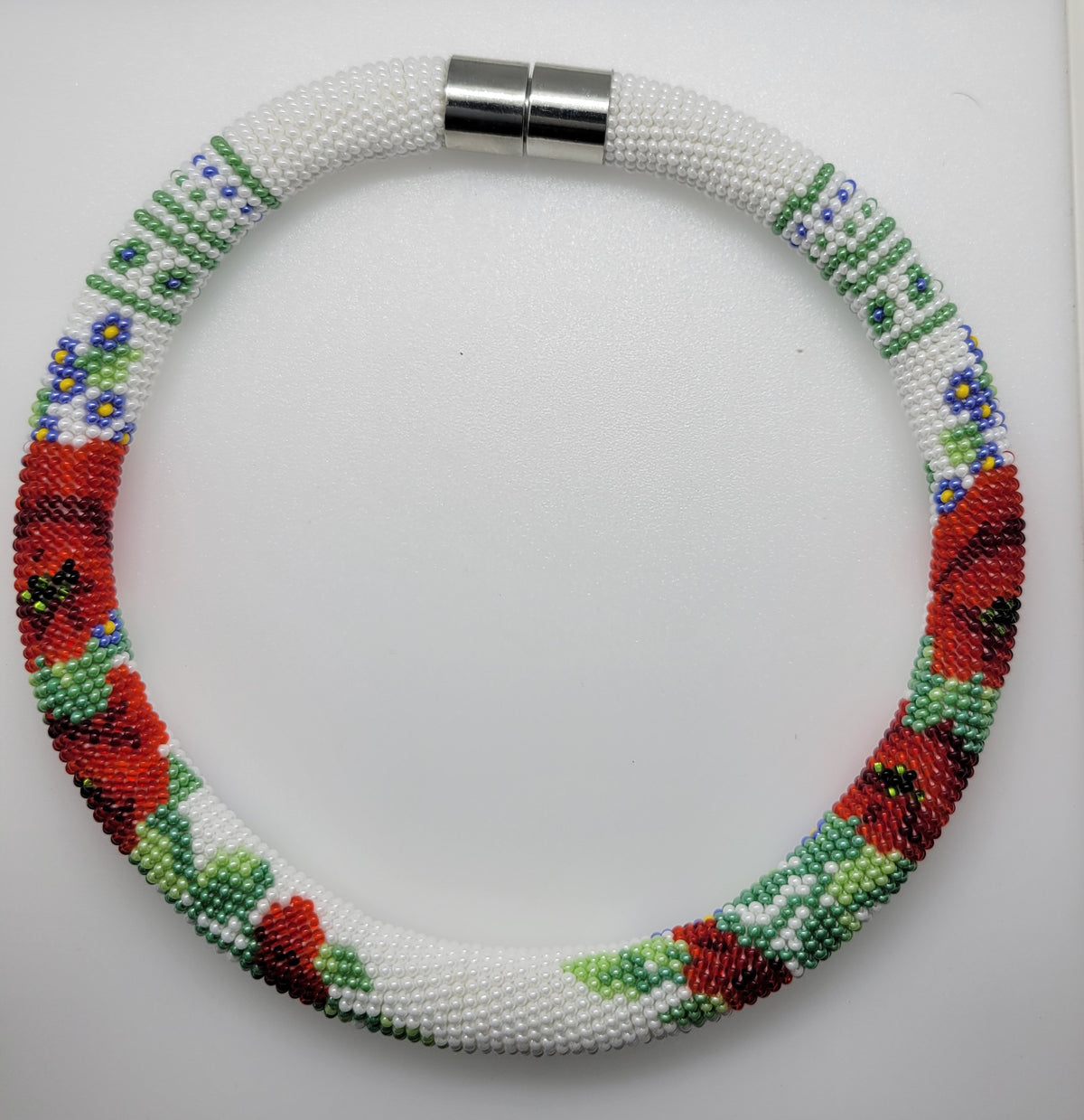 White beaded choker with red poppies, blue flowers and silver magnetic clasp on a white background