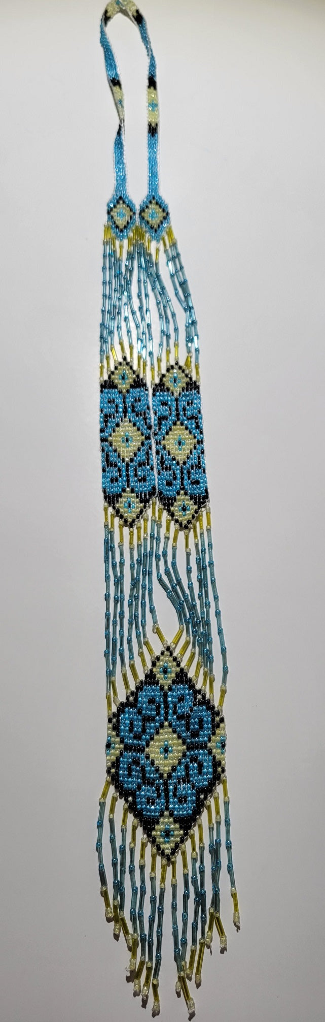 Sky blue and pale yellow beaded gerdan necklace with Ukrainian folk ornament, laid out flat