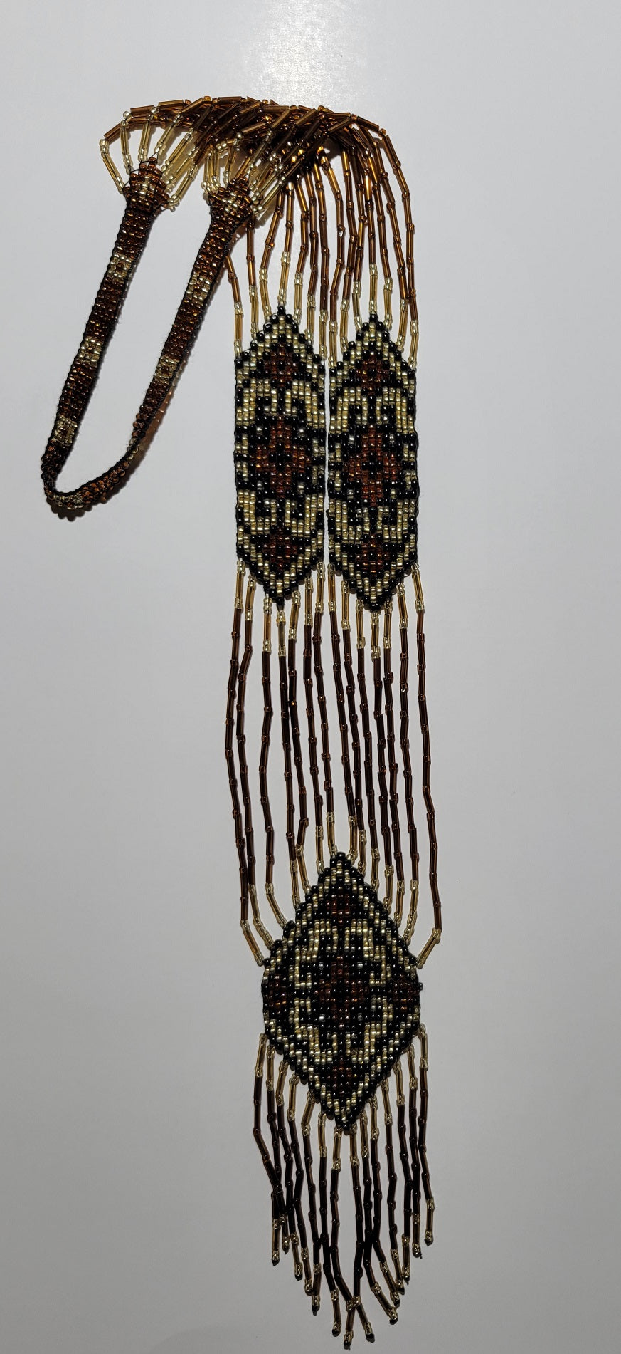 Amber, gold and brown beaded gerdan necklace with geometric diamond panels, flat lay