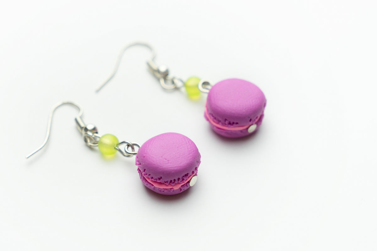 Handmade pink macaron polymer clay earrings viewed at an angle, showing textured shells and pink filling