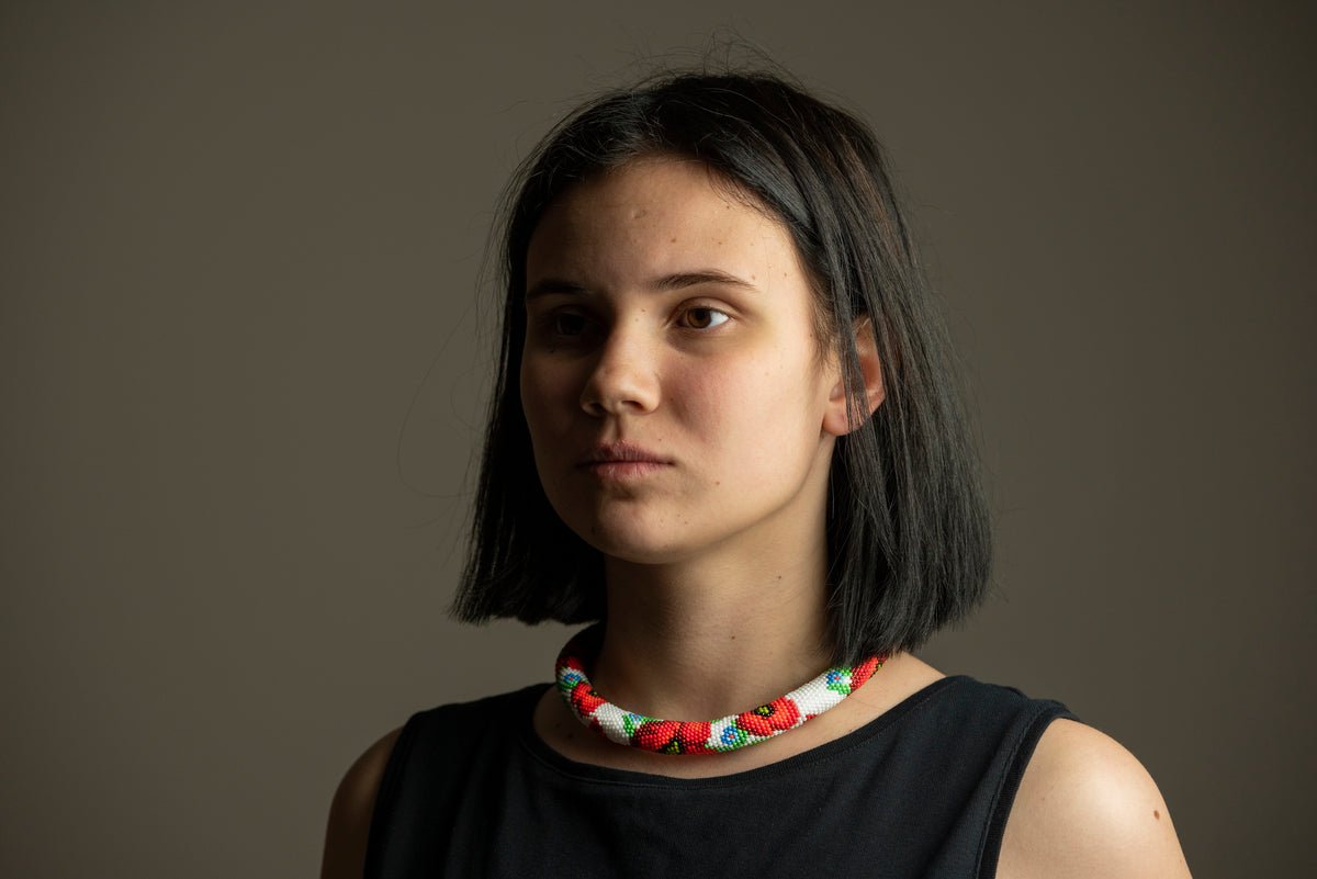 Close-up of a model wearing the red and white poppy beadwork choker, glass seed bead crochet rope