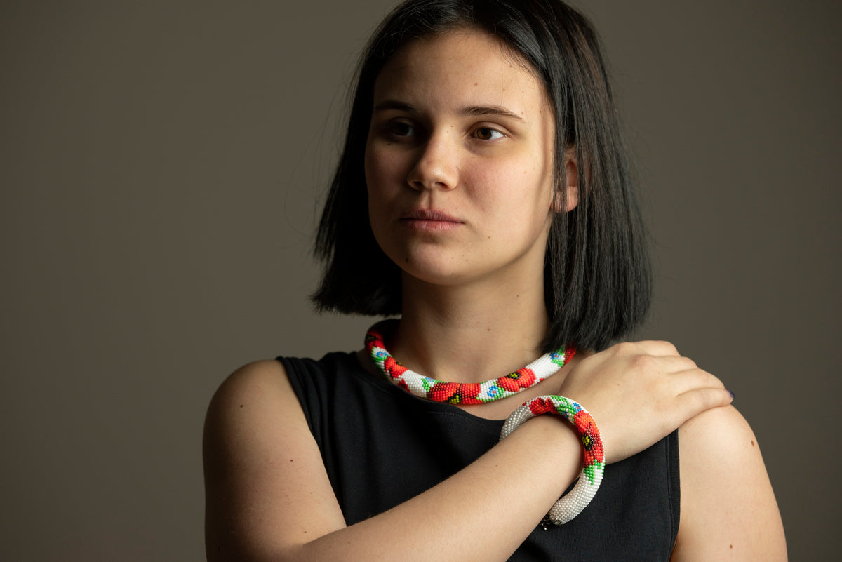 Model wearing the handmade Poppies beaded choker necklace and matching bracelet in red, white and black