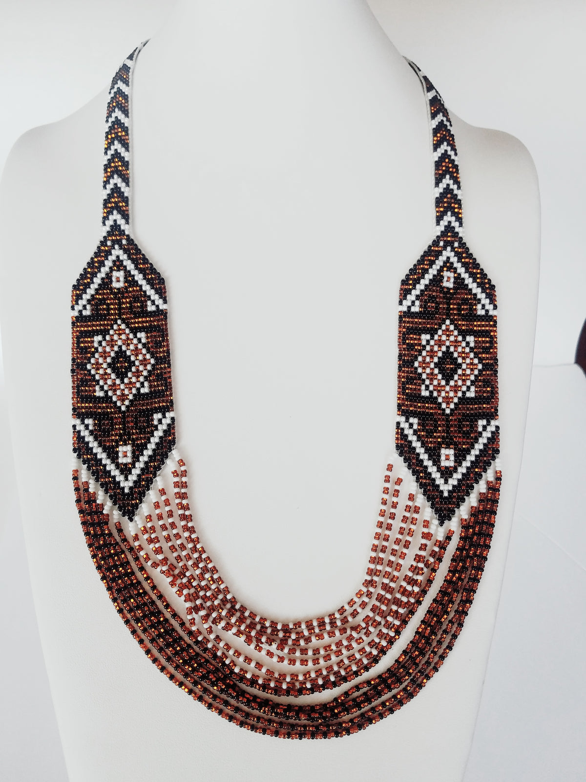 Copper brown, white and black beaded gerdan necklace with star medallions, displayed on a bust