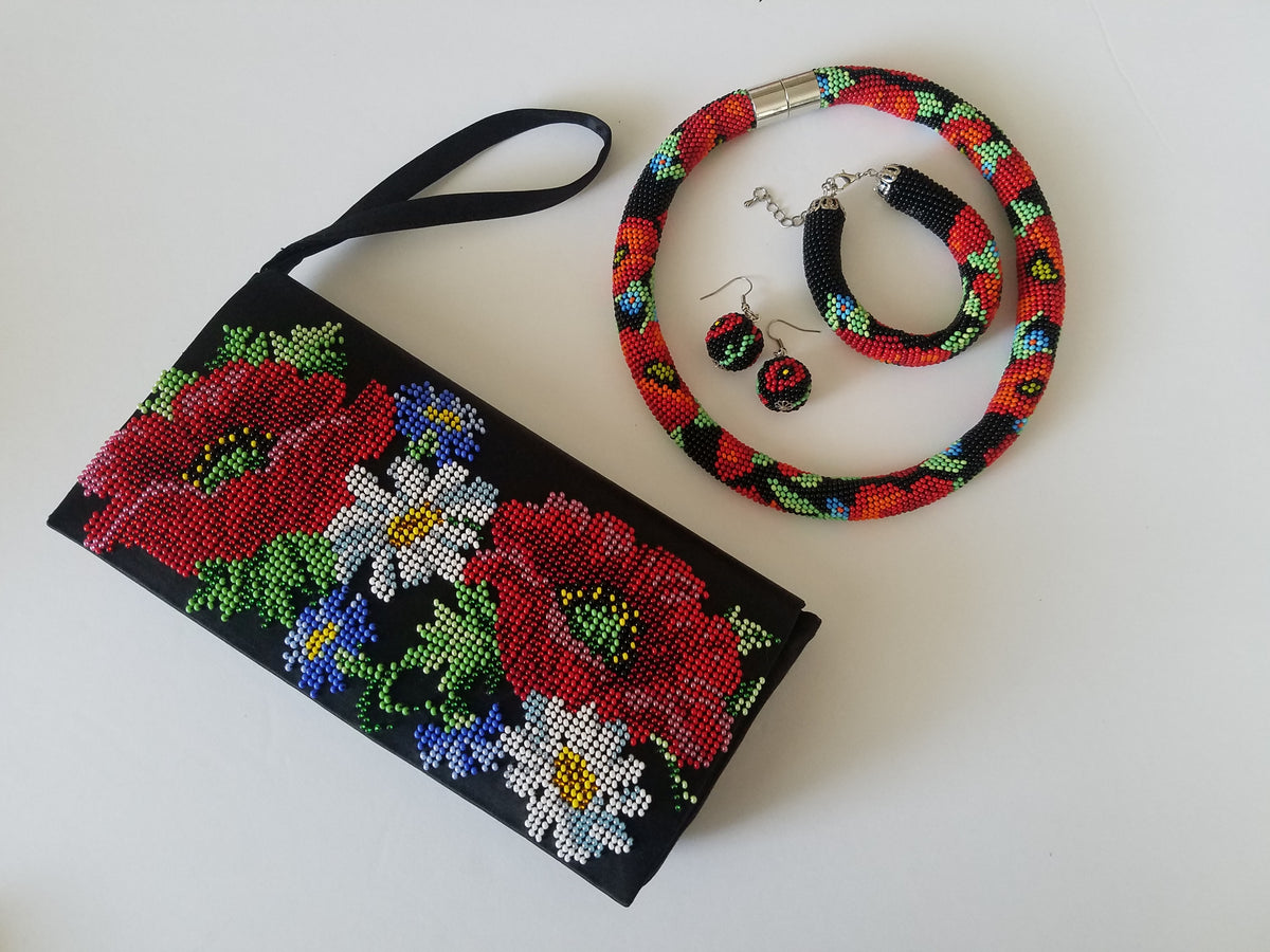 Handmade poppy choker set beside a beaded clutch purse with poppies and daisies, flat lay