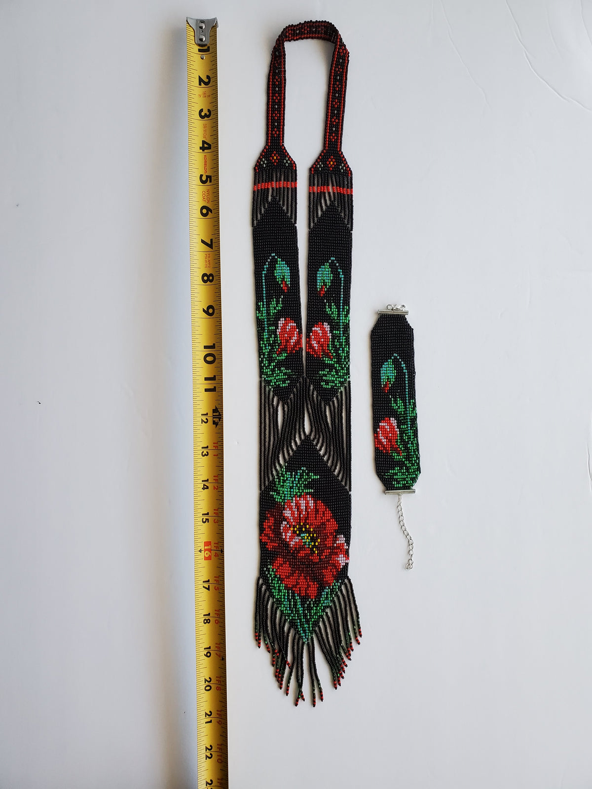 Black beaded gerdan Poppy necklace and bracelet with a yellow tape measure showing length
