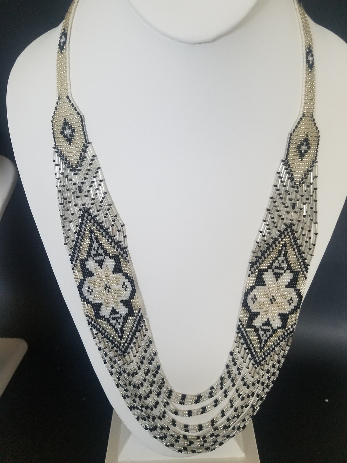 Close-up of handmade "Marichka" bead crochet necklace in silver and black seed beads with zigzag motif