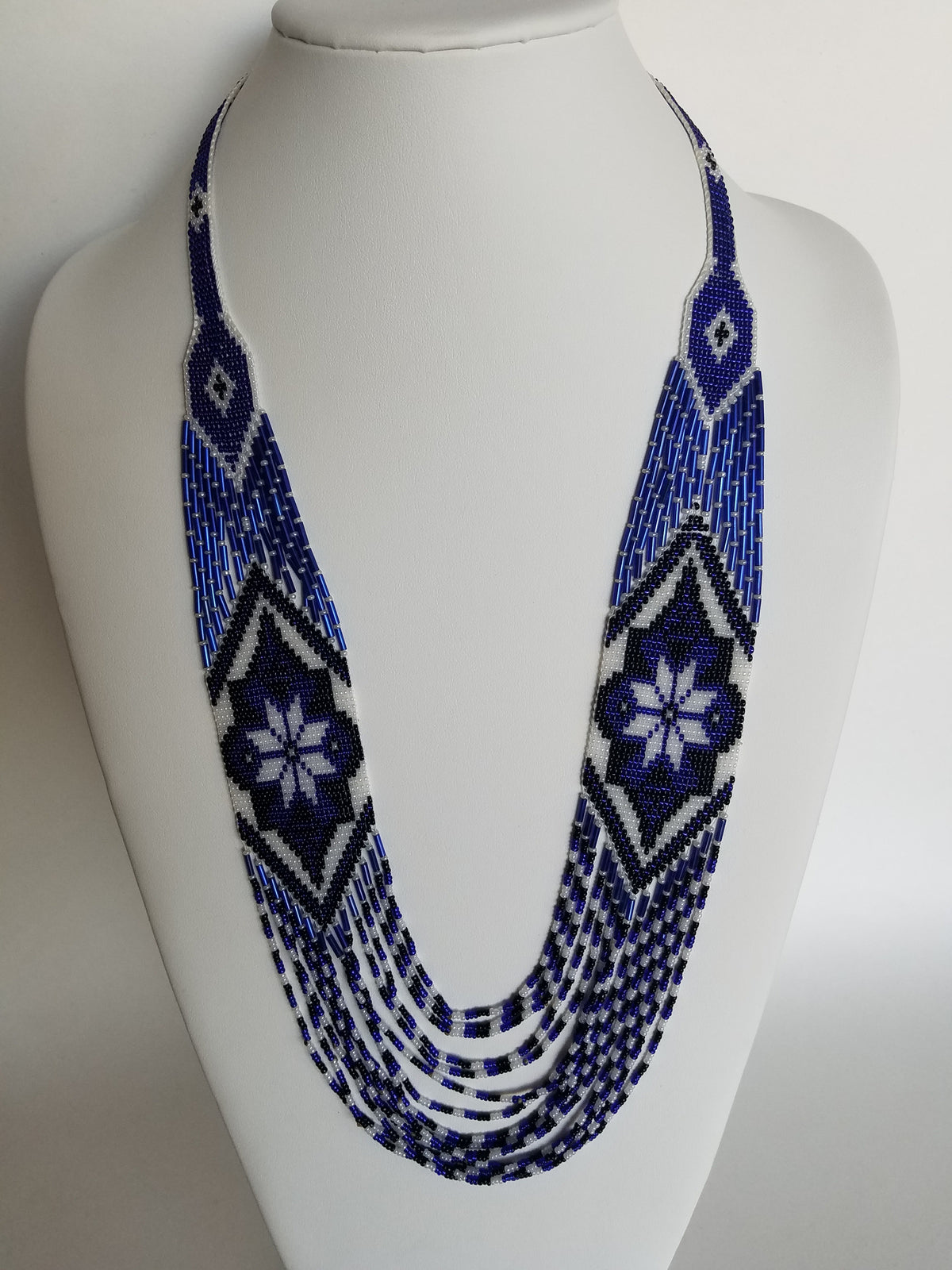 Handmade beaded necklace "Marichka" in royal blue and white seed beads, rope style on a white display bust