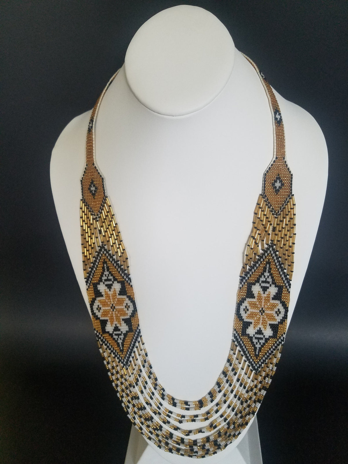 Beaded necklace "Marichka" in gold, white and black glass seed beads, crocheted rope shown on a display bust