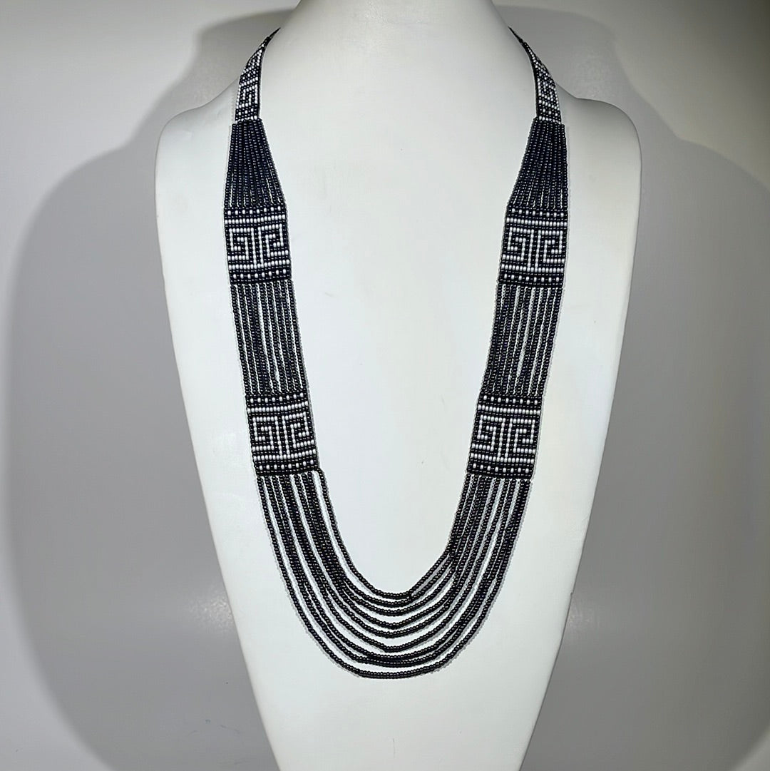 Handmade Greece necklace in dark hematite gray seed beads with white Greek key panels, on a bust