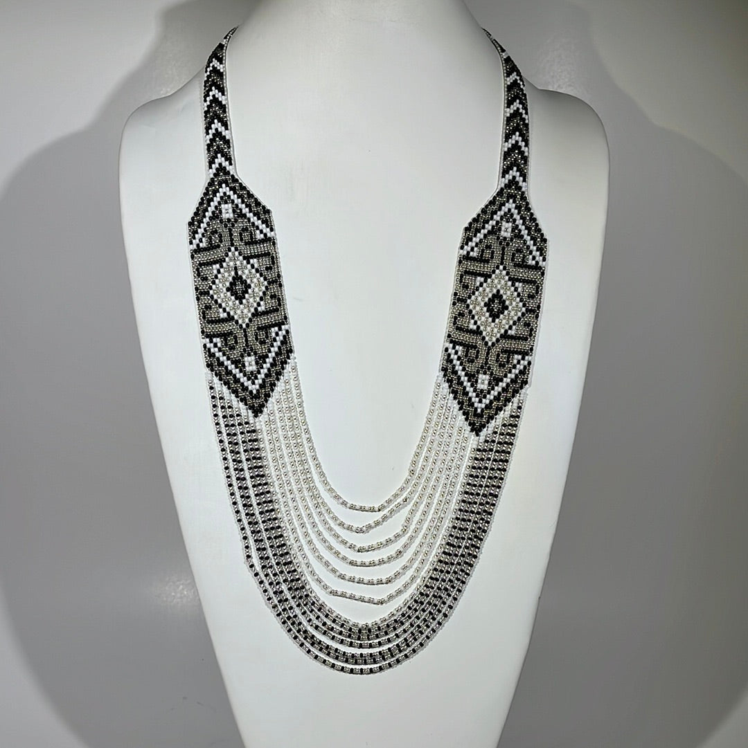 Gray, black and white handmade gerdan necklace with layered draping strands, studio shot on a bust